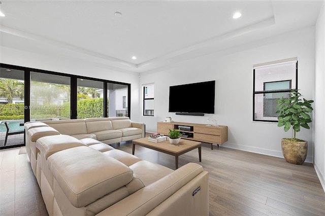 13467 Artisan Cir, Palm Beach Gardens, FL 33418 - living room featuring a tray ceiling, light wood-type flooring, and recessed lighting