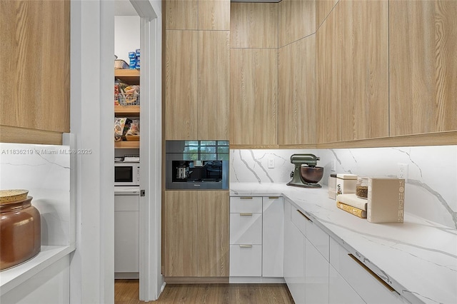 13467 Artisan Cir, Palm Beach Gardens, FL 33418 - kitchen with modern cabinets, light stone countertops, tasteful backsplash, light brown cabinets, and wood finished floors