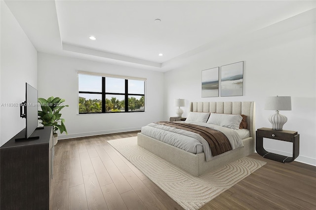 13467 Artisan Cir, Palm Beach Gardens, FL 33418 - bedroom with dark wood-style flooring, recessed lighting, and a tray ceiling