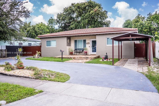 1004 NE 151st Ter, North Miami Beach, FL 33162 - ranch-style home with driveway, stucco siding, a tile roof, and a carport