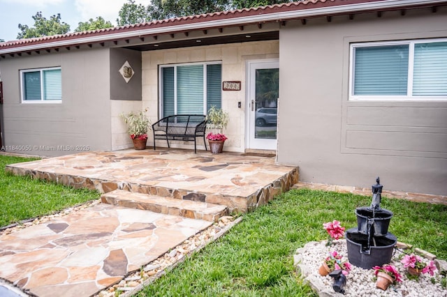 1004 NE 151st Ter, North Miami Beach, FL 33162 - property entrance featuring stucco siding, a tile roof, and a patio area