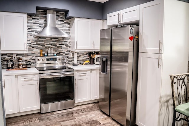 1004 NE 151st Ter, North Miami Beach, FL 33162 - kitchen featuring appliances with stainless steel finishes, wall chimney range hood, light countertops, and white cabinetry