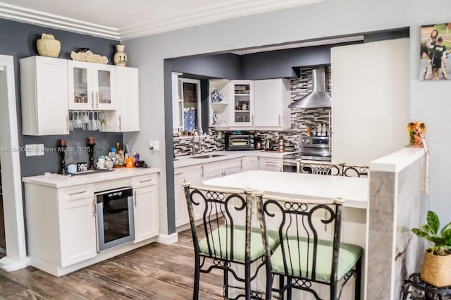 1004 NE 151st Ter, North Miami Beach, FL 33162 - kitchen featuring a kitchen bar, beverage cooler, wall chimney exhaust hood, tasteful backsplash, and stainless steel electric range