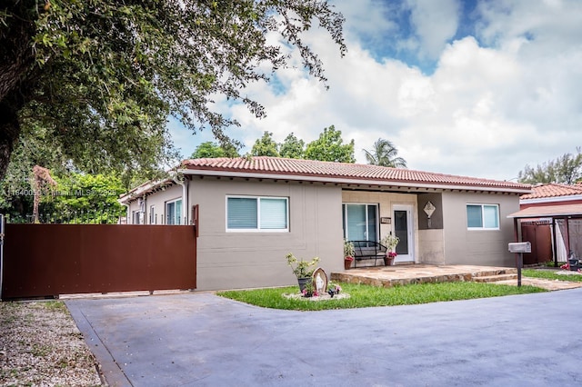 1004 NE 151st Ter, North Miami Beach, FL 33162 - view of front facade featuring a tile roof and a patio area