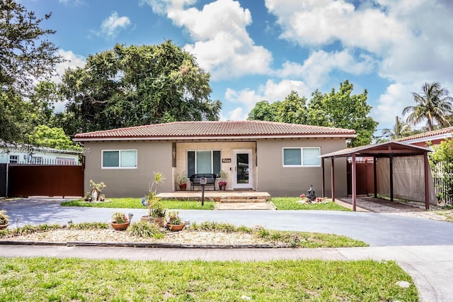 1004 NE 151st Ter, North Miami Beach, FL 33162 - view of front of house featuring a porch, concrete driveway, and a tiled roof