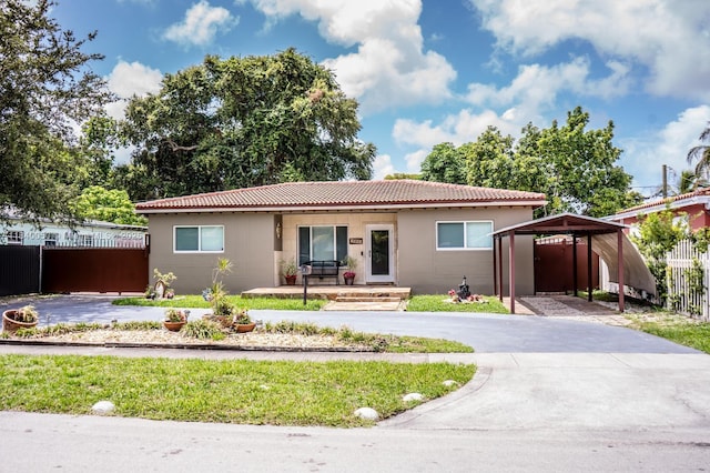 1004 NE 151st Ter, North Miami Beach, FL 33162 - single story home featuring a tiled roof, covered porch, and driveway