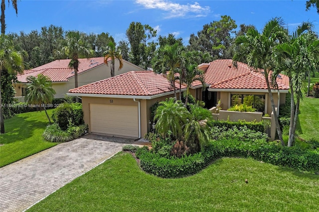 53 Northwoods Ln, Boynton Beach, FL 33436 - mediterranean / spanish house featuring an attached garage, driveway, stucco siding, and a front yard