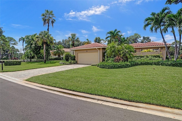 53 Northwoods Ln, Boynton Beach, FL 33436 - mediterranean / spanish-style house featuring driveway, stucco siding, an attached garage, a front yard, and a tiled roof