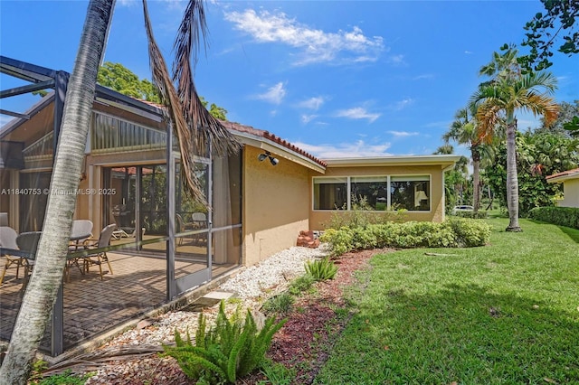 53 Northwoods Ln, Boynton Beach, FL 33436 - view of side of home featuring stucco siding, a yard, and a patio