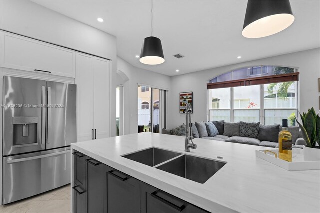 3758 SW 50th Ct, Hollywood, FL 33312 - kitchen with stainless steel fridge, light stone counters, open floor plan, decorative light fixtures, and arched walkways