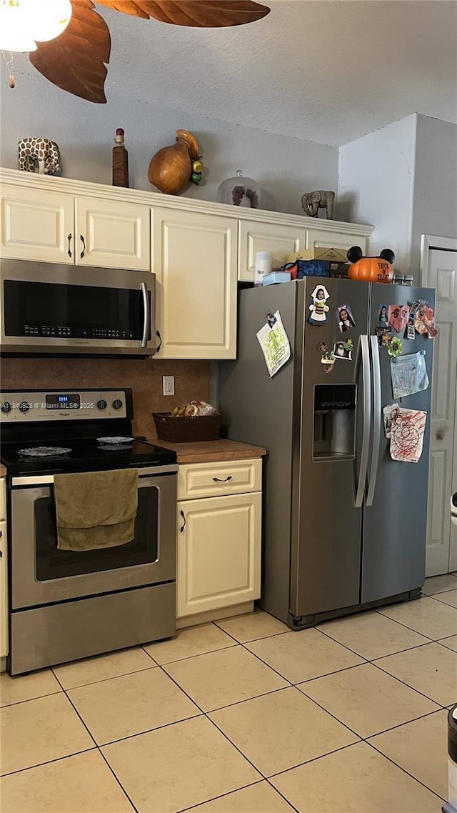 9087 SW 153rd Ct, Miami, FL 33196 - kitchen with appliances with stainless steel finishes, light tile patterned flooring, dark countertops, and white cabinetry