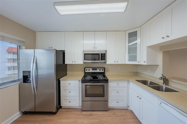 3581 Inverrary Dr Unit 308, Lauderhill, FL 33319 - kitchen featuring stainless steel appliances, light countertops, glass insert cabinets, and white cabinetry