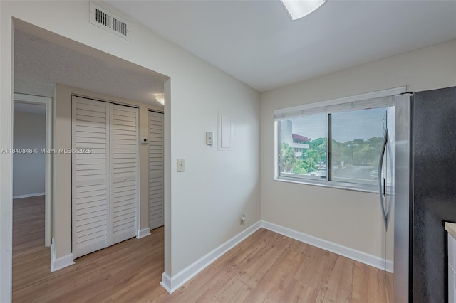 3581 Inverrary Dr Unit 308, Lauderhill, FL 33319 - unfurnished bedroom featuring freestanding refrigerator, light wood-style flooring, and a closet