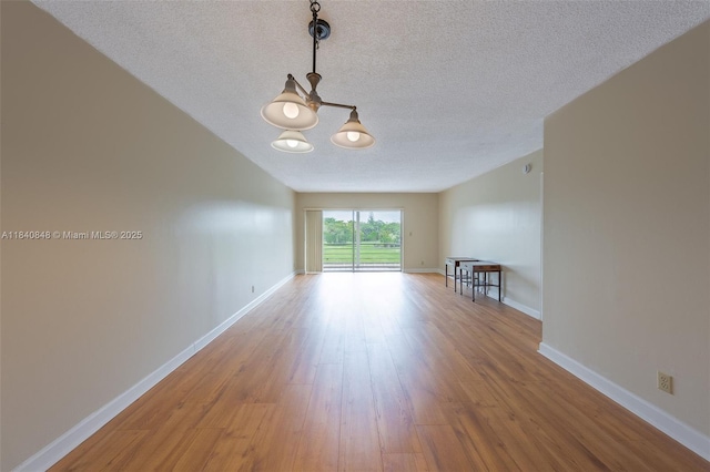 3581 Inverrary Dr Unit 308, Lauderhill, FL 33319 - empty room with a chandelier, a textured ceiling, and wood finished floors