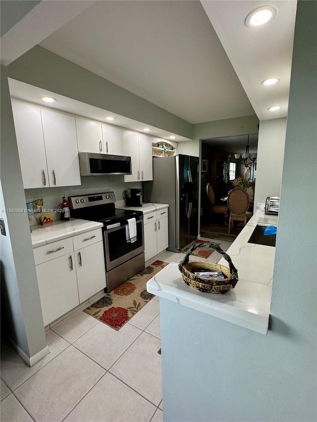 1501 SW 131st Way Unit 301P, Pembroke Pines, FL 33027 - kitchen with stainless steel appliances, white cabinetry, light countertops, light tile patterned floors, and recessed lighting