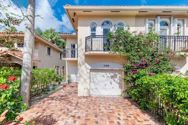 3166 Indiana St Unit I, Miami, FL 33133 - mediterranean / spanish-style home with an attached garage, a balcony, stucco siding, and decorative driveway