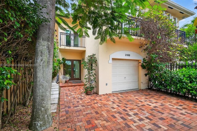 3166 Indiana St Unit I, Miami, FL 33133 - view of front facade with french doors, a balcony, stucco siding, and a garage