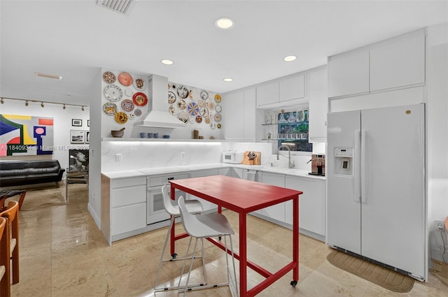 3166 Indiana St Unit I, Miami, FL 33133 - kitchen with white appliances, custom exhaust hood, light countertops, white cabinets, and recessed lighting