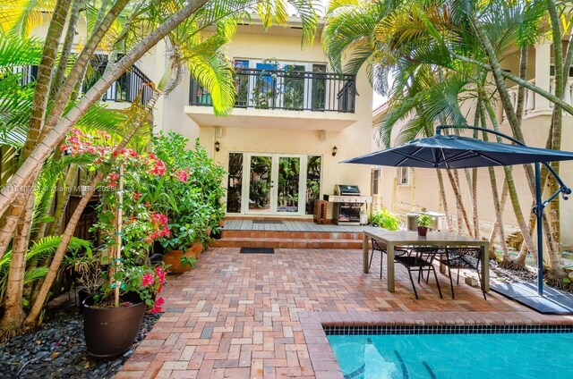 3166 Indiana St Unit I, Miami, FL 33133 - back of house featuring stucco siding, a balcony, a patio, an outdoor pool, and french doors