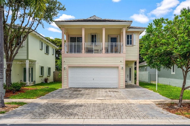 3135 NE 4th St, Homestead, FL 33033 - view of front facade featuring decorative driveway, an attached garage, a balcony, and stucco siding