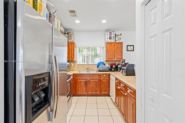 3135 NE 4th St, Homestead, FL 33033 - kitchen with appliances with stainless steel finishes, brown cabinetry, light countertops, light tile patterned floors, and recessed lighting
