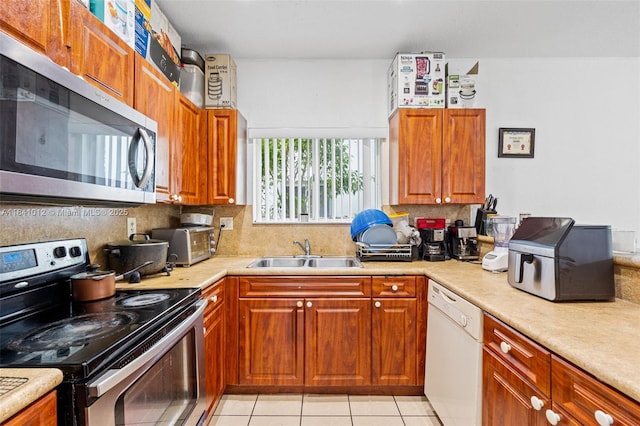 3135 NE 4th St, Homestead, FL 33033 - kitchen with stainless steel appliances, decorative backsplash, light countertops, light tile patterned floors, and brown cabinetry