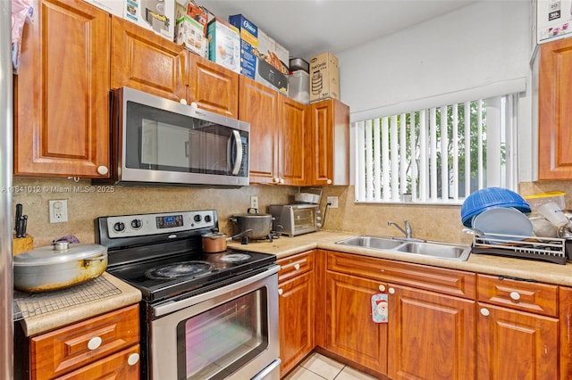 3135 NE 4th St, Homestead, FL 33033 - kitchen featuring appliances with stainless steel finishes, light countertops, and brown cabinetry
