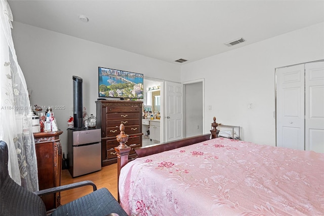 3135 NE 4th St, Homestead, FL 33033 - bedroom with light wood-type flooring, freestanding refrigerator, a closet, and ensuite bathroom