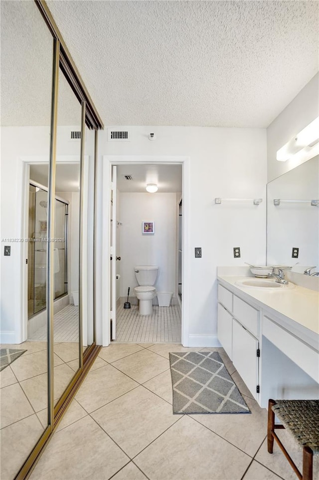 2215 Cypress Island Dr Unit 707, Pompano Beach, FL 33069 - bathroom with vanity, a textured ceiling, a shower stall, and tile patterned floors