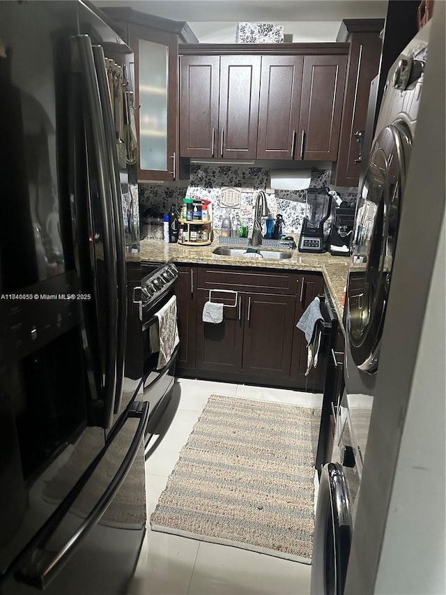13810 SW 112th St Unit 106, Miami, FL 33186 - kitchen featuring black appliances, dark brown cabinetry, light stone countertops, and glass insert cabinets