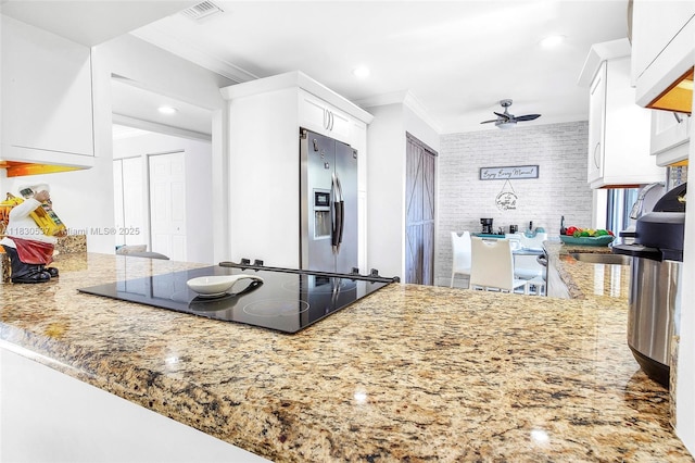 16041 Fairway Ter Unit 121, Weston, FL 33326 - kitchen with ornamental molding, stainless steel fridge with ice dispenser, black electric stovetop, ceiling fan, and white cabinetry
