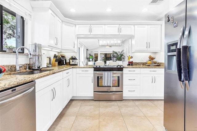 16041 Fairway Ter Unit 121, Weston, FL 33326 - kitchen with appliances with stainless steel finishes, light stone counters, white cabinets, light tile patterned floors, and vaulted ceiling
