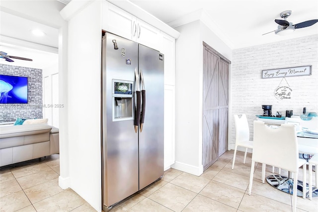16041 Fairway Ter Unit 121, Weston, FL 33326 - kitchen featuring a ceiling fan, stainless steel fridge, light tile patterned floors, white cabinets, and brick wall