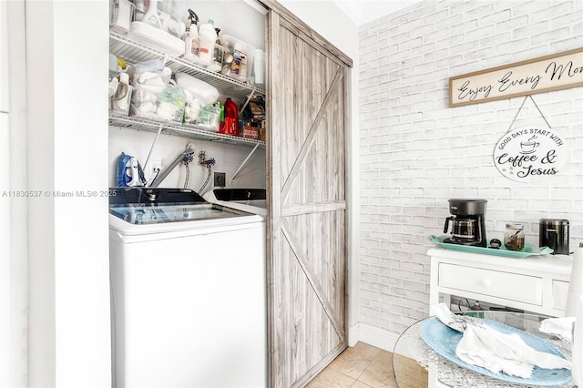 16041 Fairway Ter Unit 121, Weston, FL 33326 - laundry area featuring brick wall, washing machine and clothes dryer, and light tile patterned flooring