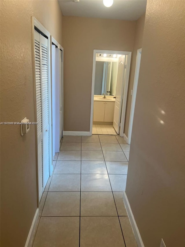 1666 SE 27th Ct Unit 208, Homestead, FL 33035 - hallway featuring light tile patterned flooring and baseboards