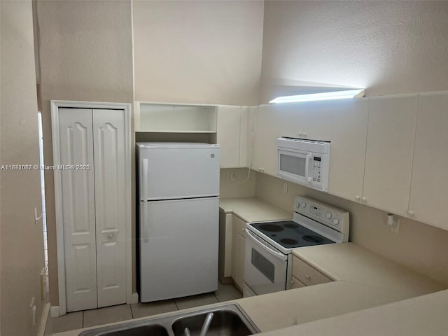1666 SE 27th Ct Unit 208, Homestead, FL 33035 - kitchen featuring white appliances, light countertops, white cabinetry, light tile patterned floors, and open shelves