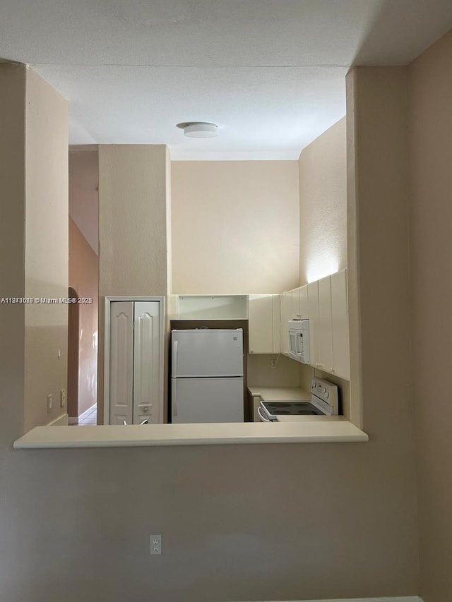 1666 SE 27th Ct Unit 208, Homestead, FL 33035 - kitchen featuring white appliances, light countertops, and a peninsula