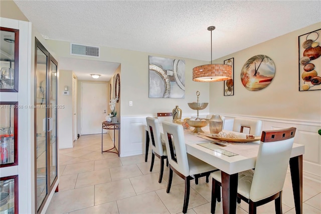 3651 Environ Blvd Unit 461, Lauderhill, FL 33319 - dining area with a wainscoted wall, a textured ceiling, light tile patterned floors, and a decorative wall