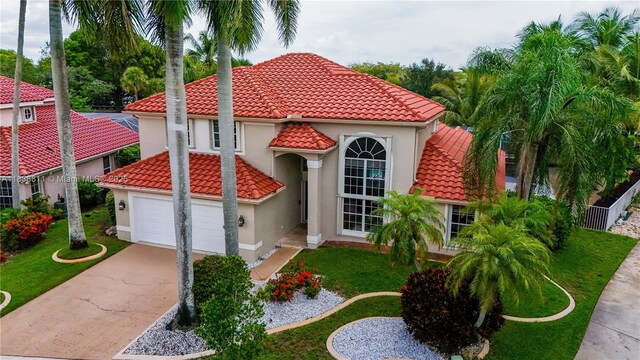 1503 NW 178th Ln, Pembroke Pines, FL 33029 - mediterranean / spanish house with concrete driveway, stucco siding, an attached garage, a tile roof, and a front yard