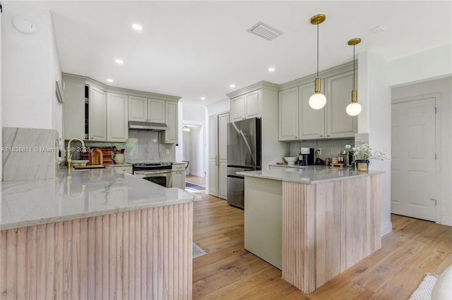 1503 NW 178th Ln, Pembroke Pines, FL 33029 - kitchen with a peninsula, appliances with stainless steel finishes, backsplash, light wood-style flooring, and recessed lighting