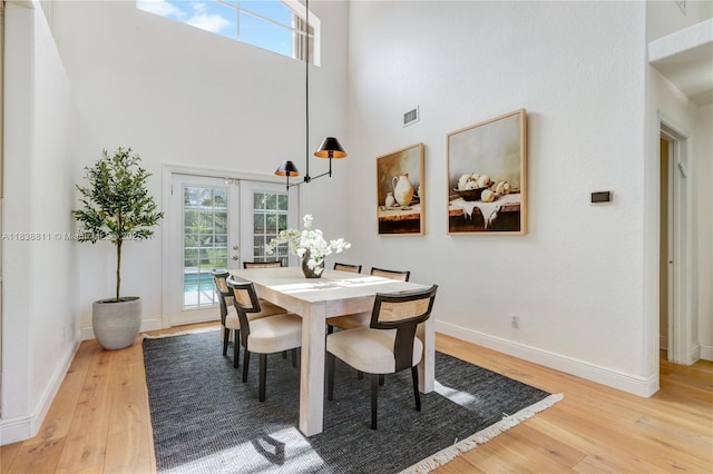 1503 NW 178th Ln, Pembroke Pines, FL 33029 - dining space featuring light wood-type flooring, a towering ceiling, plenty of natural light, and french doors