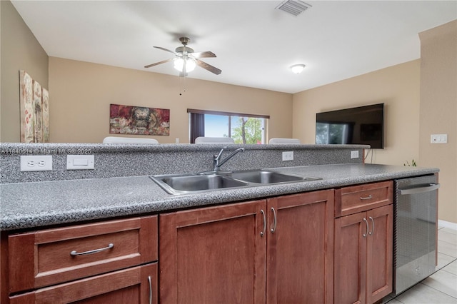 14053 SW 49th St Unit 7, Miramar, FL 33027 - kitchen with light tile patterned flooring, stainless steel dishwasher, a ceiling fan, and brown cabinetry