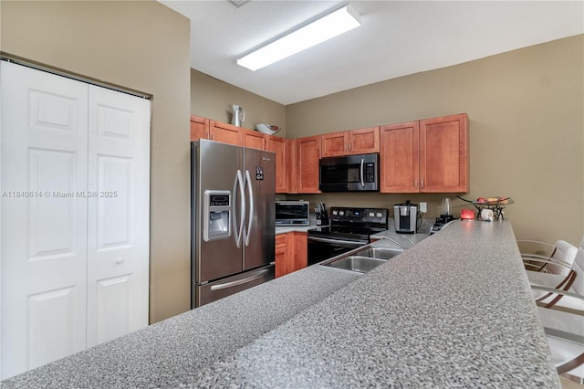 14053 SW 49th St Unit 7, Miramar, FL 33027 - kitchen with stainless steel appliances, a peninsula, light countertops, and a breakfast bar