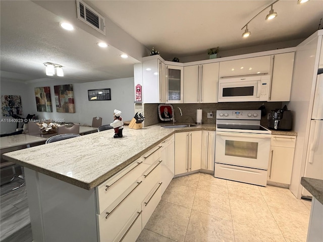11 Olive Dr Unit E, Hialeah, FL 33010 - kitchen featuring white appliances, a peninsula, glass insert cabinets, tasteful backsplash, and recessed lighting