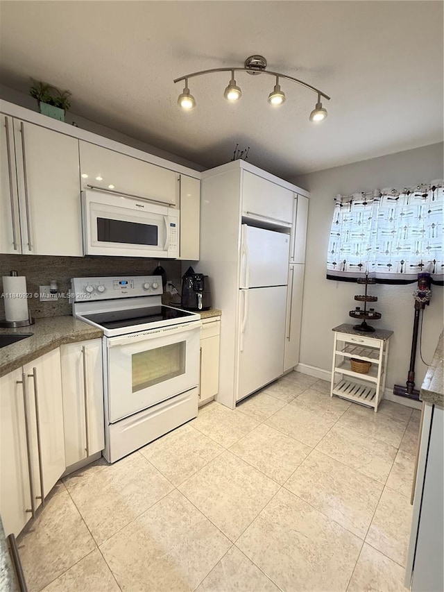 11 Olive Dr Unit E, Hialeah, FL 33010 - kitchen with white appliances, light tile patterned flooring, and white cabinetry