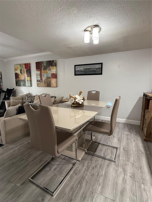 11 Olive Dr Unit E, Hialeah, FL 33010 - dining space featuring wood finished floors, a textured ceiling, and crown molding
