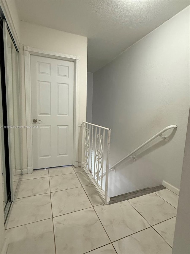 11 Olive Dr Unit E, Hialeah, FL 33010 - stairs featuring a textured ceiling and baseboards