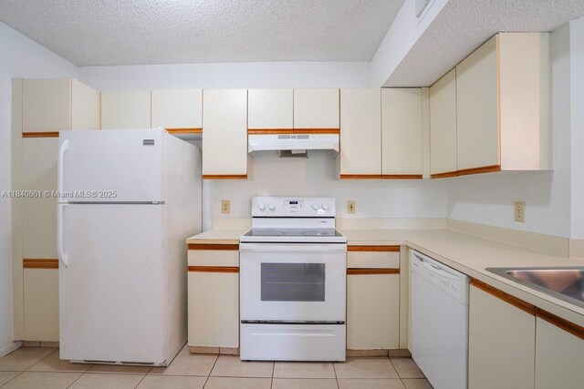 9033 Wiles Rd Unit 304, Coral Springs, FL 33067 - kitchen featuring white appliances, light countertops, light tile patterned flooring, under cabinet range hood, and a textured ceiling