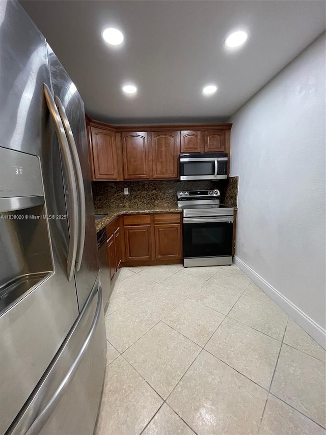 9143 SW 77th Ave Unit B105, Miami, FL 33156 - kitchen featuring stainless steel appliances, decorative backsplash, light tile patterned floors, dark stone countertops, and recessed lighting
