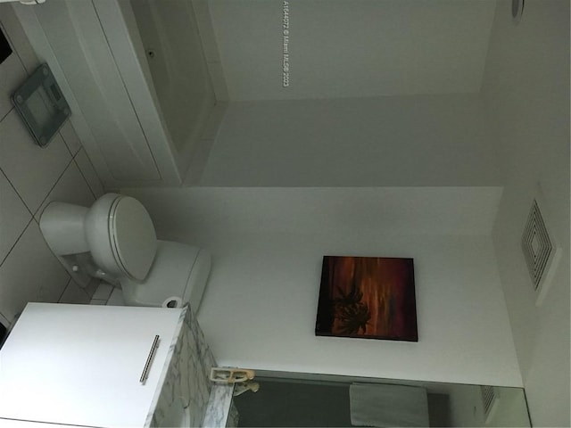 bathroom featuring tile flooring, toilet, and vanity